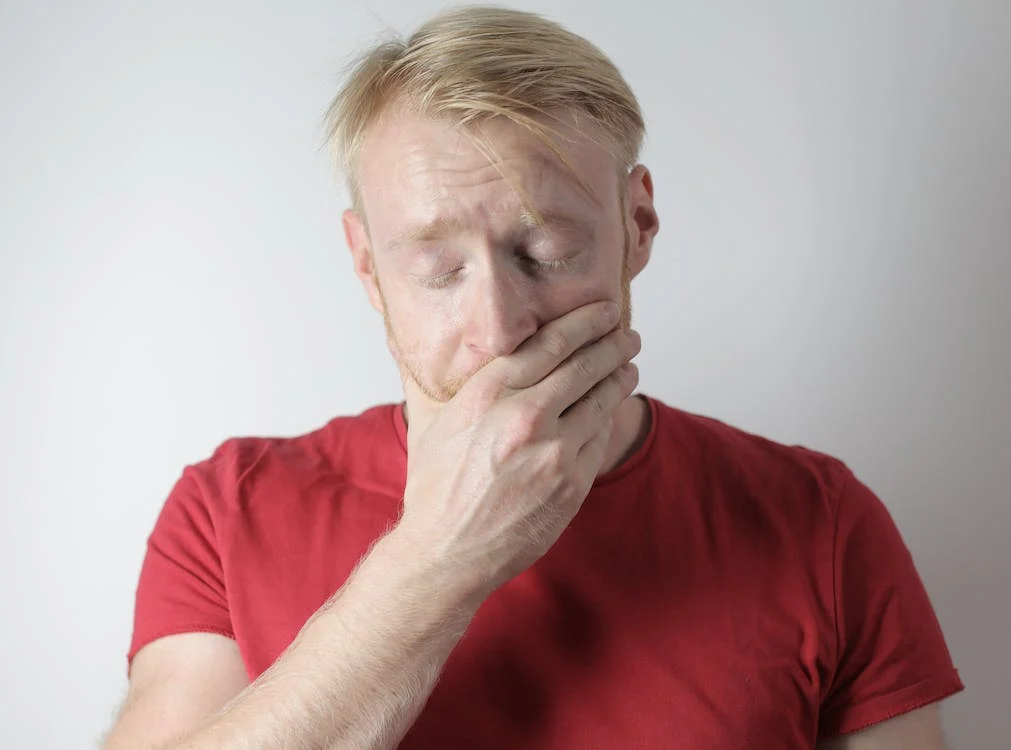 a man covering his mouth due to dental discomfort