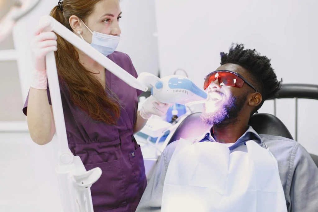 a dental professional performing teeth whitening on her patient