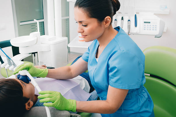 a dental professional applying laughing gas to a pediatric patient  before a dental procedure