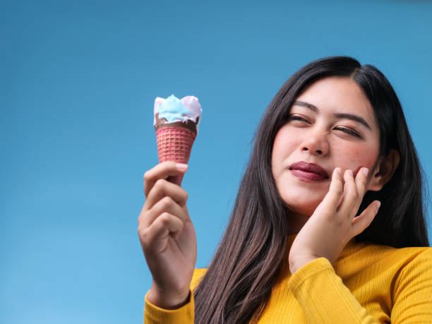 a woman experiencing tooth sensitivity after eating ice-cream