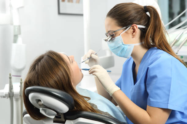 image of a dentist examining her patient's teeth